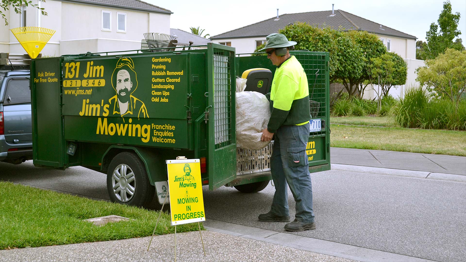 Jim's franchisee unloading equipment from a branded trailer